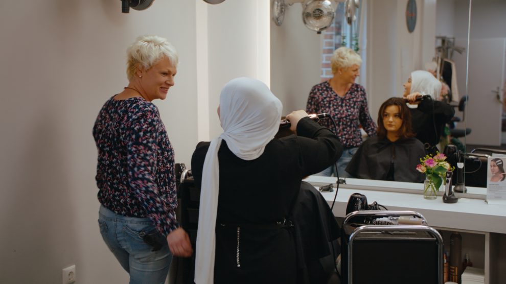 Saliha aus Syrien hat mit der Ausbildung im Friseursalon Brünger in Wallenhorst ihre Berufung gefunden. Foto: Szene aus dem Film / Servicestelle SGB II