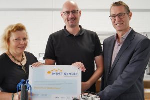 Geschafft – die Realschule Wallenhorst ist erneut als MINT-Schule Niedersachsen rezertifiziert! Bei der Übergabe des neuen Schulschilds strahlten Schulleiter Stefan Schmidt, Lehrer Markus Holznagel (u. a. Fachbereichsleitung MINT) und Kerstin Pentermann (Projektkoordinatorin VME-Stiftung Osnabrück-Emsland) – von rechts nach links. Foto: VME-Stiftung, Jana Billigmann