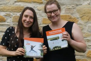 Rebecca Reuter und Magdalena Menke von der Ländlichen Erwachsenenbildung (LEB) in Wallenhorst mit dem neuen Katalog Kindheitspädagogik 2024/25. Foto: LEB