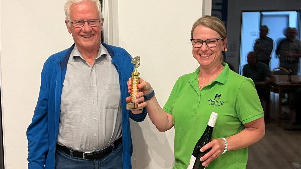 Steffi Kühl überreicht Alfons Schröer den „St. Josef Cup“ und eine Flasche Kolping-Wein. Foto: Alexander Kühl / Kolpingsfamilie Hollage