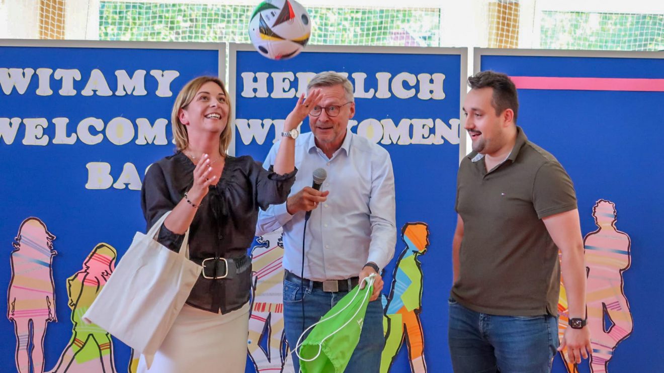 Bürgermeister Otto Steinkamp überreicht Schulleiterin Anna Stokłos einen Fußball als Präsent für die Schule. Dolmetscher Patrik Romanowski übersetzt die Ansprache für die Gäste. Foto: Paweł Pietrzak