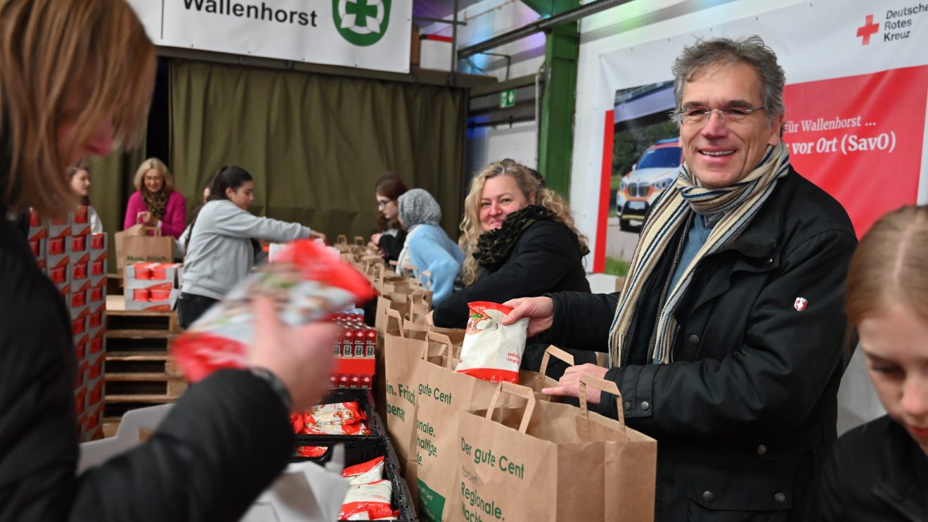 Packstraße in Wallenhorst: Zahlreiche ehrenamtliche Helferinnen und Helfer, hier mit Regionalbischof Friedrich Selter (rechts), packten die Tüten mit Zutaten für Weihnachtskekse und Pflegeprodukte. Foto: Urte Tegtmeyer