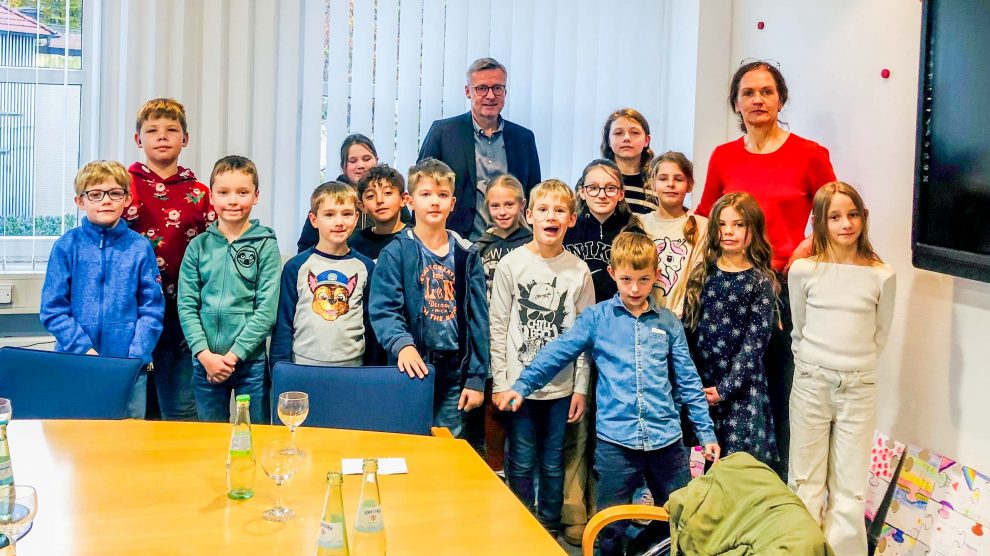 Kinder der Erich-Kästner-Schule überreichen mit ihrer Lehrerin Sandra Nee Puzzleteile an Bürgermeister Otto Steinkamp. Foto: Beatrix Weber-Dahlmann