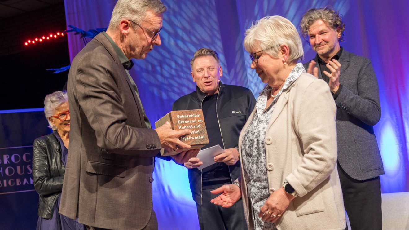 Bürgermeister Otto Steinkamp überreicht Christel Mysliworski den Stein des Anstoßes 2024. Foto: Gemeinde Wallenhorst / André Thöle